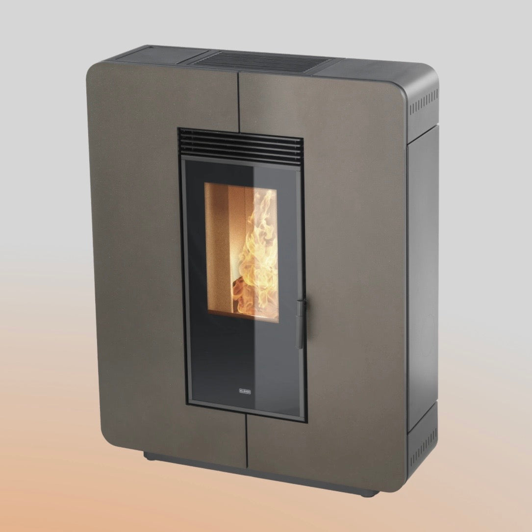 Stufa a pellet Astra 100 S di Klover, vista frontale con display digitale e porta in acciaio, in ambiente domestico.