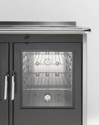 Stufa a legna Klover Star 90 Inox con porta in vetro e corpo in acciaio inossidabile, progettata per riscaldamento efficiente.