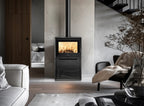 Stufa a legna Klover Venus 110s Plus in ambiente domestico, con porta in vetro e design moderno.