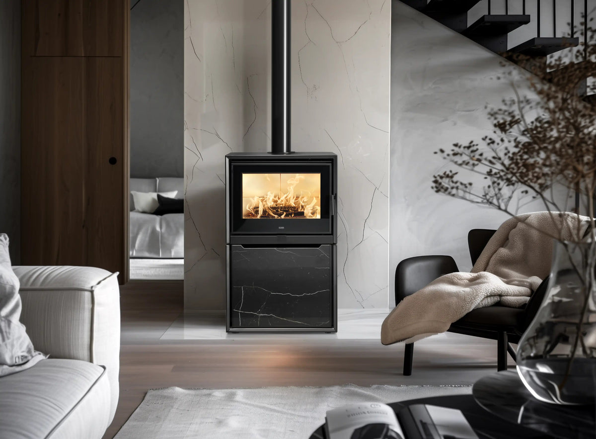 Stufa a legna Klover Venus 110s Plus in ambiente domestico, con porta in vetro e design moderno.