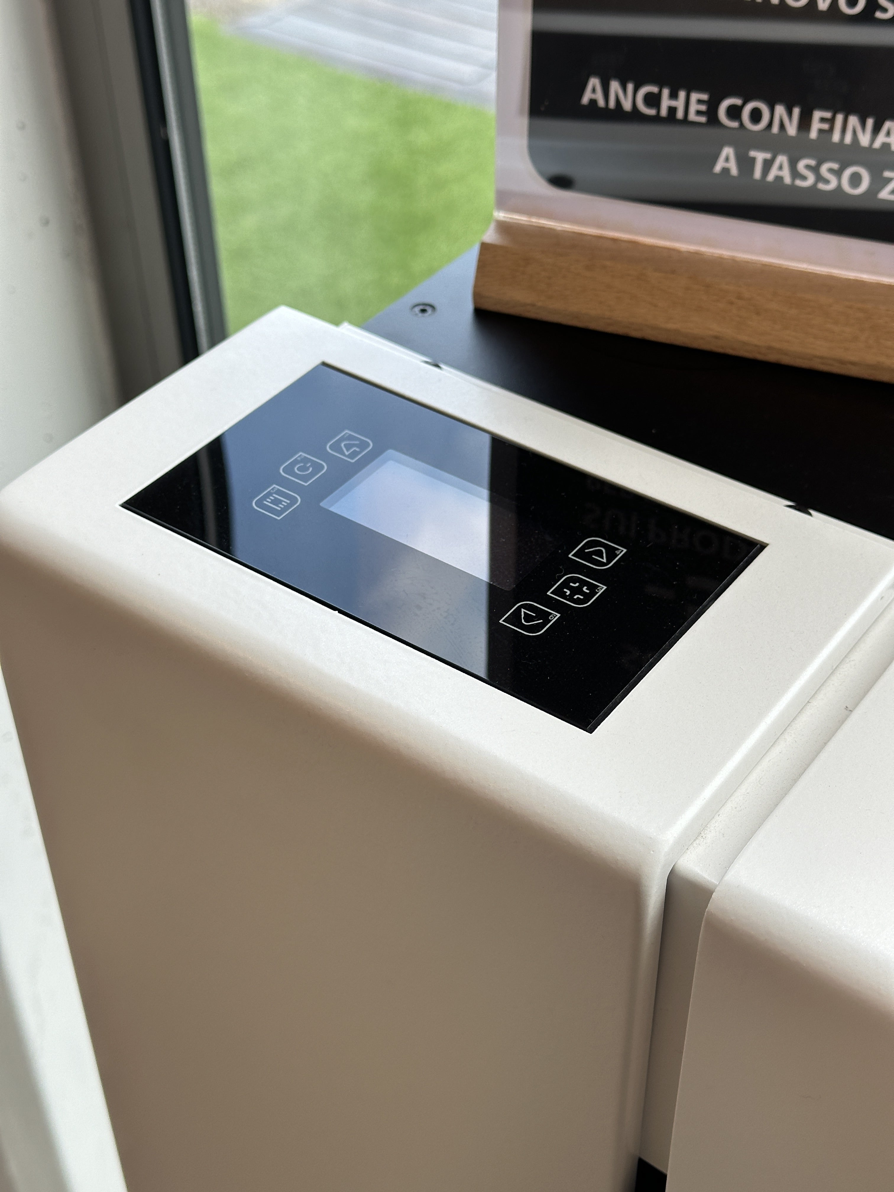 Stufa a pellet Dielle Ostro 100 Bianca, con design moderno e pannello di controllo, in ambiente domestico.