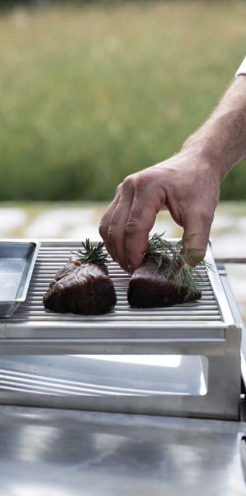 Kit accessori per barbecue Fògher per cottura indiretta e affumicatura, include griglie e supporti in acciaio inox.