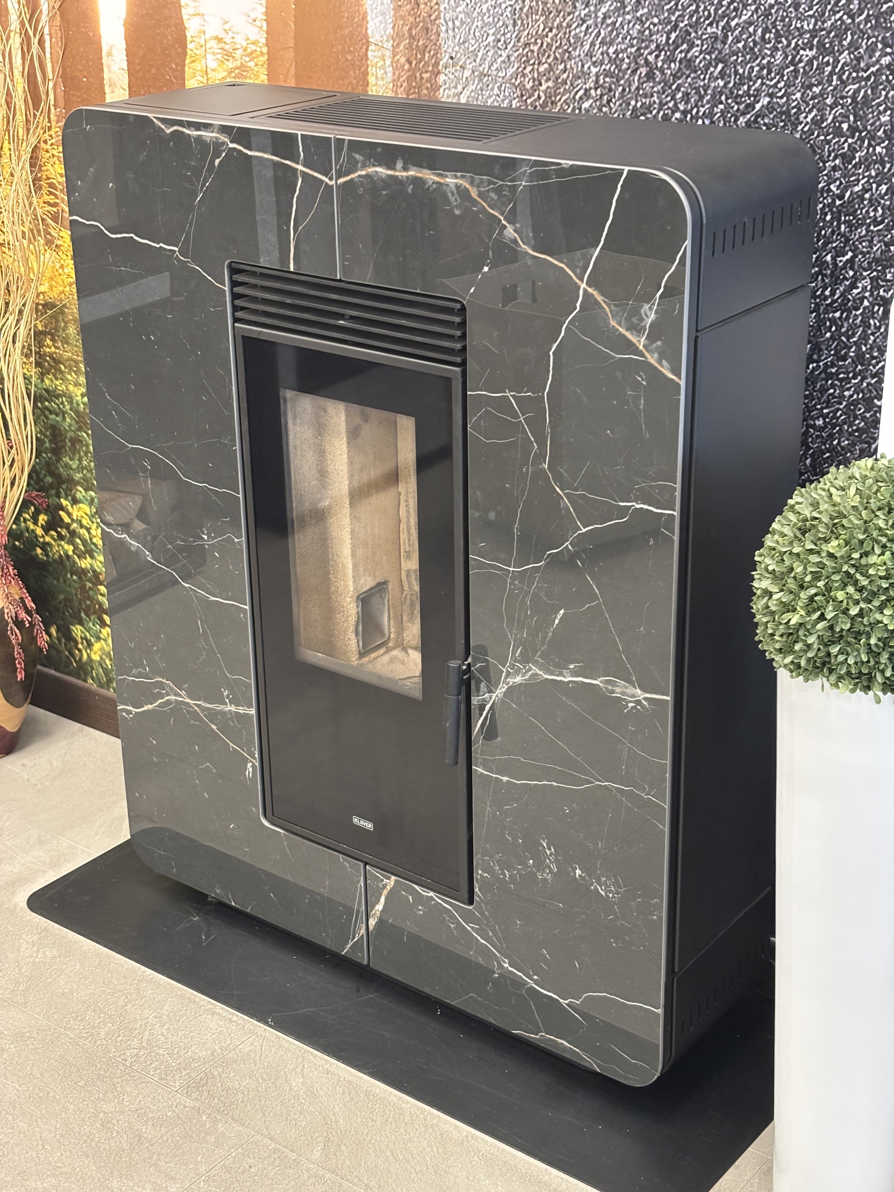 Stufa a pellet Astra Multi-Air Klover con finitura in gres grigio, vista frontale con porta e dettagli del sistema di riscaldamento