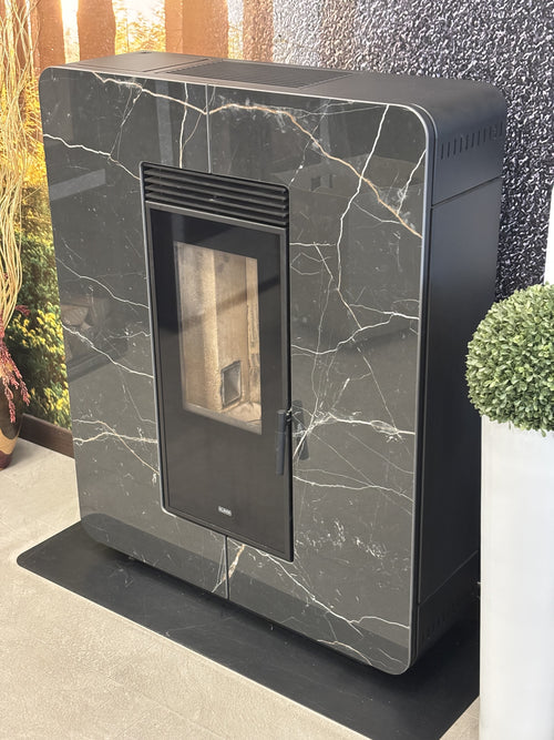 Stufa a pellet Astra Multi-Air Klover con finitura in gres grigio, vista frontale con porta e dettagli del sistema di riscaldamento