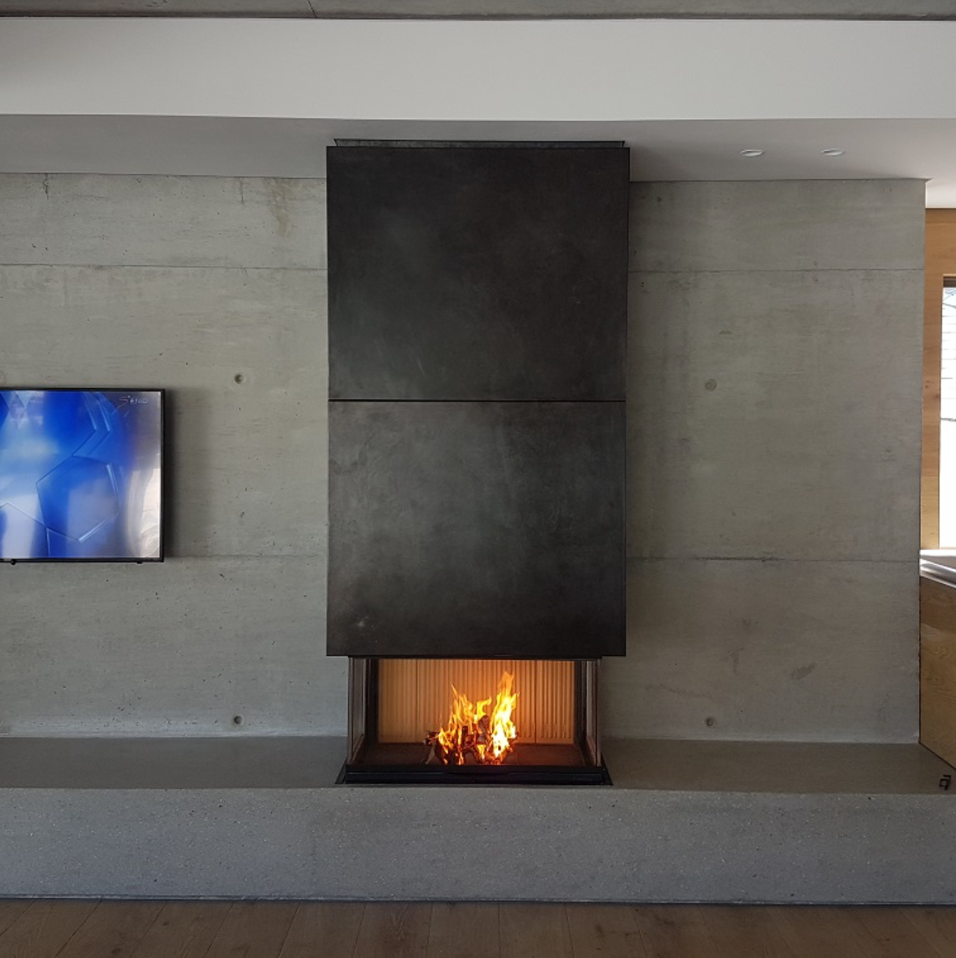 Caminetto a legna Piazzetta MA 271 SL+ con piedini, design elegante e apertura frontale, in ambientazione domestica.