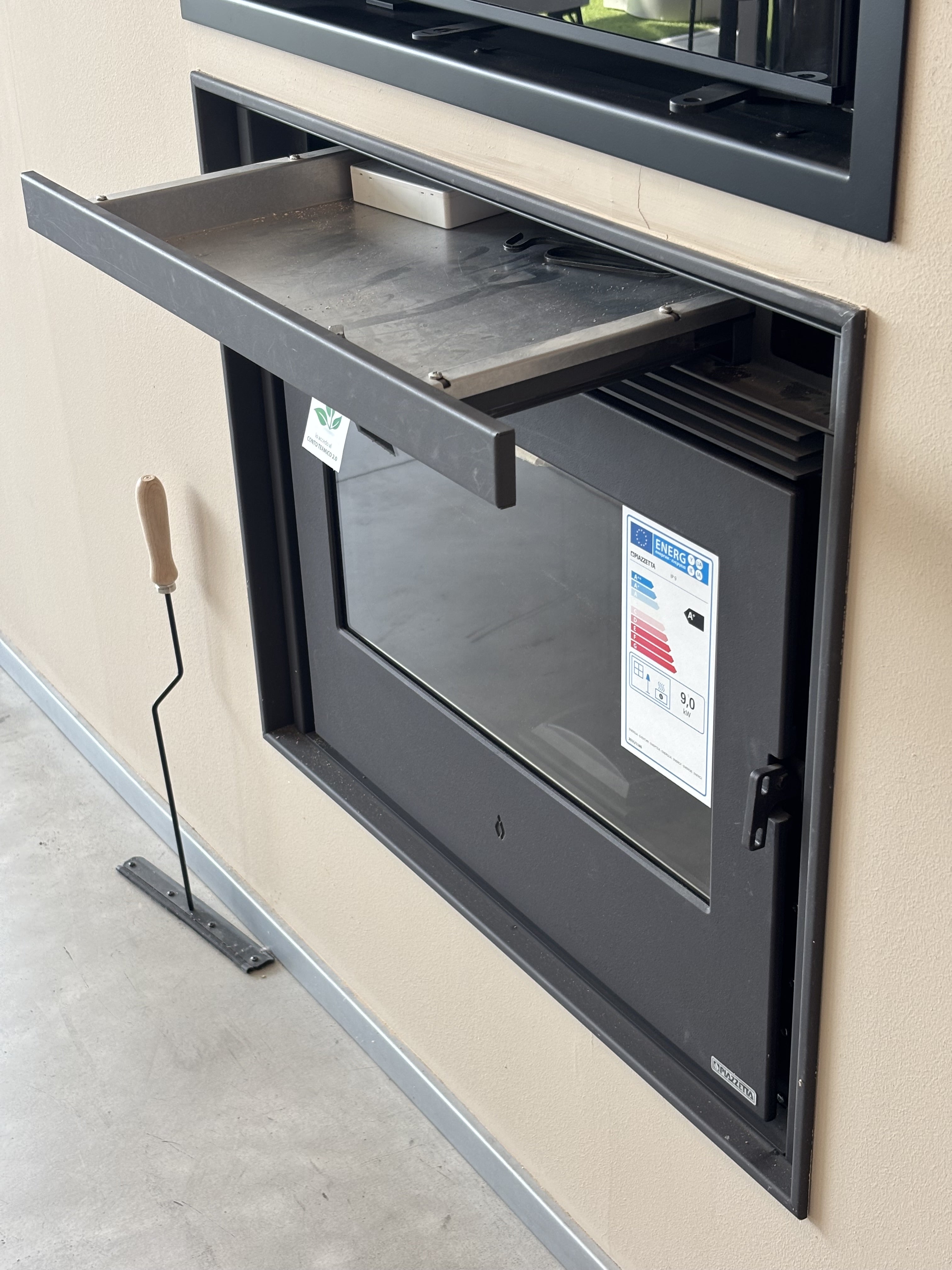 Porta in ghisa IP 9 per camino a pellet Piazzetta, robusta e resistente, visibile con dettagli di finitura in ferro.