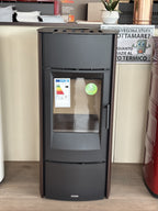 Stufa a legna Piazzetta E 530 Steel con design moderno e rivestimento in acciaio, visibile con porta e maniglie.