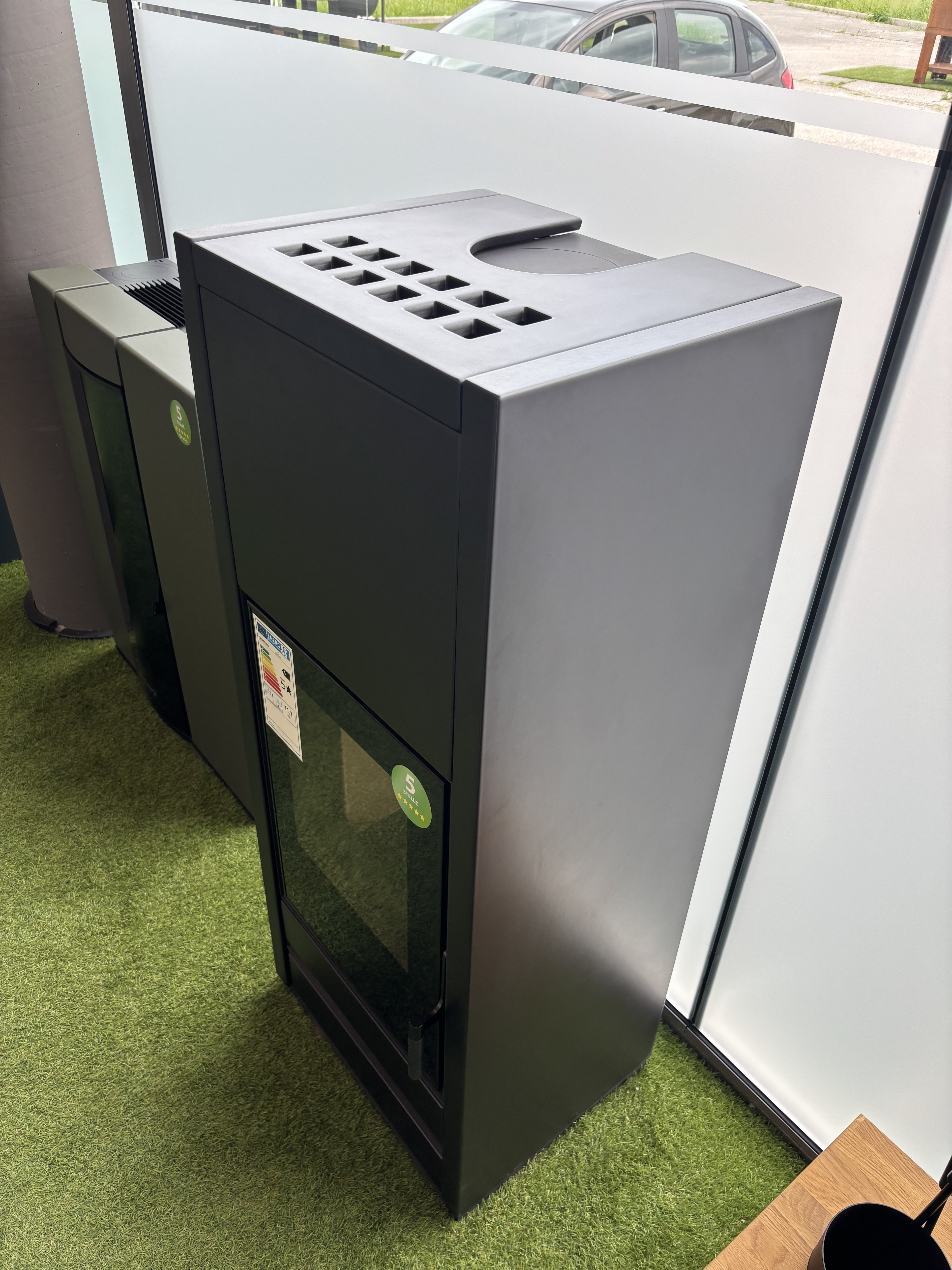 Stufa a legna Piazzetta E 928 M BCS con design elegante e struttura in pietra, ideale per riscaldare ambienti domestici.